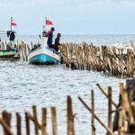 Sejumlah nelayan bersama personel TNI AL membongkar pagar laut yang terpasang di kawasan pesisir Tanjung Pasir, Kabupaten Tangerang, Banten, Sabtu (18/1/2025).